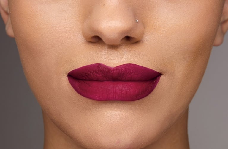 Uma boca com batom vermelho radiante da linha Power Stay e sem borrões.